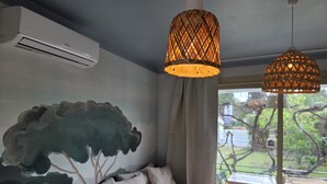 A modern living room with a large sofa, a wall-mounted air conditioner, and two hanging lamps. - - (Hyères)