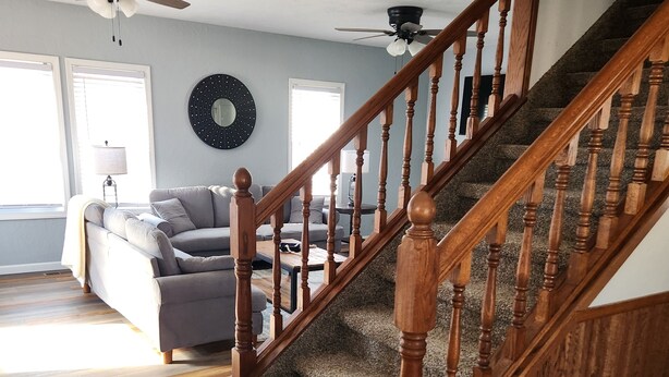 A staircase with wooden balusters and carpeted steps leading to a landing. - Spacious 4-bedroom house in Cherokee with AC (Cherokee)