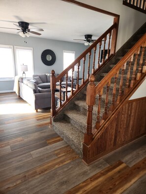 A staircase with wooden balusters and carpeted steps leading to a landing. - Spacious 4-bedroom house in Cherokee with AC (Cherokee)