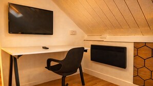 A modern room with a desk, chair, TV, and a hexagonal-patterned wall. - Convenient 3BR Apartment near ExCel, O2 Arena w/Parking, Link to Central London (London)