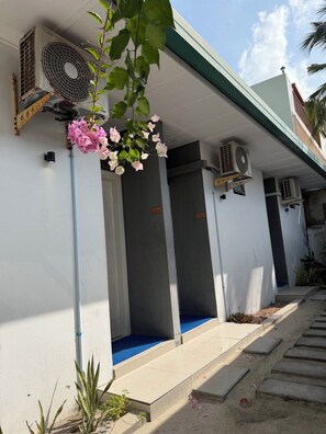 A building with a covered entrance, air conditioning units, and a blue carpeted area. - Dhiyares (Kelaa)