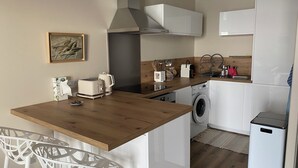 A compact kitchen with a wooden countertop, a washing machine, a built-in oven, and a small refrigerator. - The balconies of Bouzigues l'hippocampe (Bouzigues)