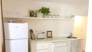 Eine Küche mit Kühlschrank, Toaster, Spüle und Schränken.