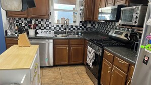 A kitchen with wooden cabinets, a stainless steel refrigerator, a microwave, a stove, and a dishwasher. - Spacious 4-bedroom house in Augusta about 22 min from Augusta National Golf Club (Augusta)