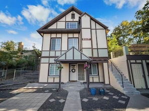 A two-story building with a traditional architectural style, featuring a prominent entrance with a small porch and a door with a wreath. - Cozy Browne’s Addition Apt Near Downtown (Spokane)