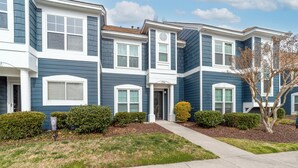 A row of townhouses with a central entrance, a covered porch, and a small front yard with trimmed bushes. - Tuscany Lane Townhouse - 2 floors, Near Lake, Pool, Pets OK - LKN Location (Cornelius)