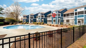 A multi-story residential building with a swimming pool, a fenced patio area, and a red location marker. - Tuscany Lane Townhouse - 2 floors, Near Lake, Pool, Pets OK - LKN Location (Cornelius)