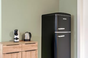 A black refrigerator with the brand name SEVERIN, placed next to a wooden cabinet with a coffee maker and a kettle. - Attilia House. Brand new one bedroom apartment for your unforgettable vacation in Sirmione (Sirmione)