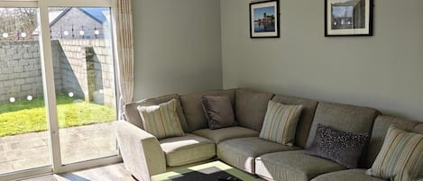 A living room with a sectional sofa, a coffee table, and two framed pictures on the wall.