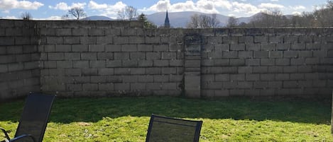 A brick wall with a grassy area in front.