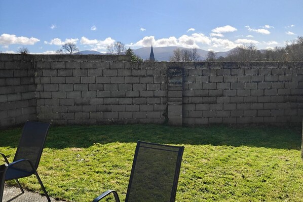 A brick wall with a grassy area in front. - 4 Bed House Sleeps 8 - Enclosed Garden - Parking (Killarney)