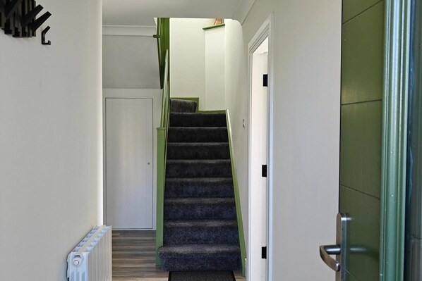 A staircase with carpeted steps leading to a door.