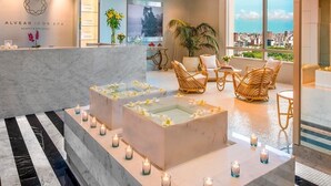 Un área de spa con mostrador de recepción, zona de estar y vistas a la ciudad.