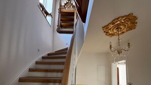 A staircase with wooden steps and a handrail, leading to a room with a radiator and a door. - Panorama Joy #1 (EG) (Schmallenberg)