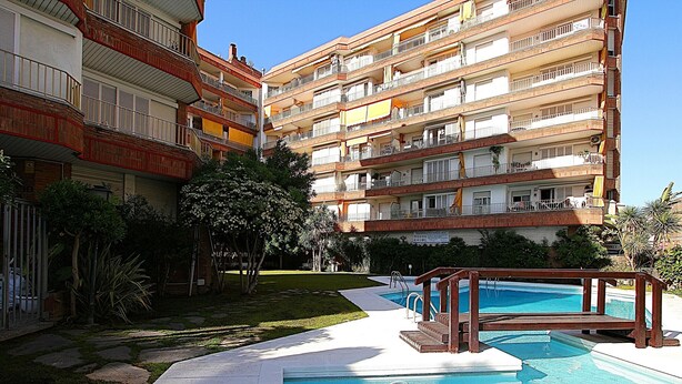 A multi-story residential building with a swimming pool, a small garden area, and a visible balcony. - Apartment for 4, near beach - AC (Lloret de Mar)
