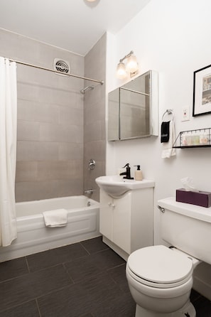 Un bagno moderno dotato di vasca, doccia, lavandino e WC.