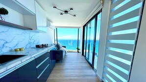 Una cucina moderna con vista sull'oceano, un'area pranzo con vista e un'ampia porta scorrevole in vetro.