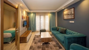 Una camera d'albergo moderna con un letto, una poltrona, un tavolino da caffè e una TV.