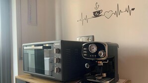 Keittiössä on mikroaaltouuni ja kahvinkeitin, ja ne on sijoitettu puiseen työtasoon.