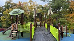 A playground with a slide, climbing structures, and a bridge. - Sleeps 10 - 5BR - Minutes to Campus - Next to Park, Golf, Shopping (Ames)