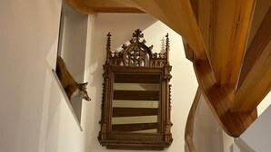 Una escalera de madera con un espejo tallado en la pared.