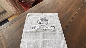 Una mesa de madera con un mantel individual blanco que presenta un logotipo y texto.