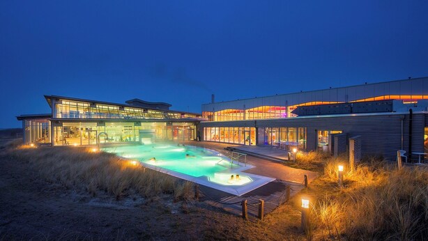 Un bâtiment moderne doté d’une piscine et d’un éclairage extérieur.