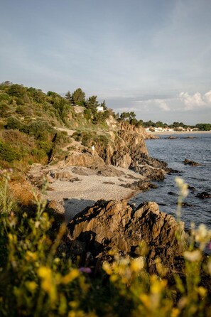 A coastal landscape with rocky terrain, vegetation, and a distant view of a beach and houses. - L'escale Bleue, T2 apartment 300m from the beach 🏖️ in Argelès sur Mer (Argelès-sur-Mer)
