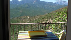 Ein Balkon mit Blick auf grüne Hügel und Berge.