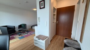 En moderne stue med en sofa, et lille bord, et tæppe og en dør til et andet rum.