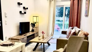 Una sala de estar moderna con una televisión, una mesa de comedor y un sofá.