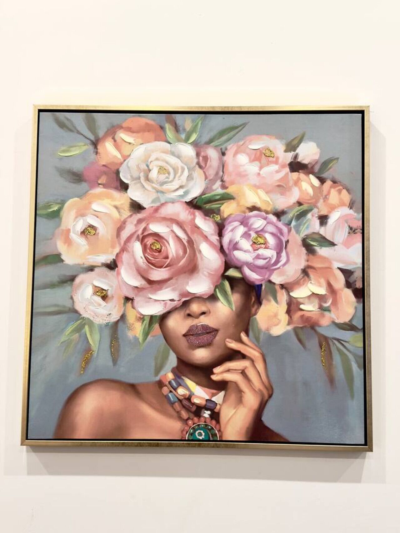 A framed painting of a person with a floral headpiece.