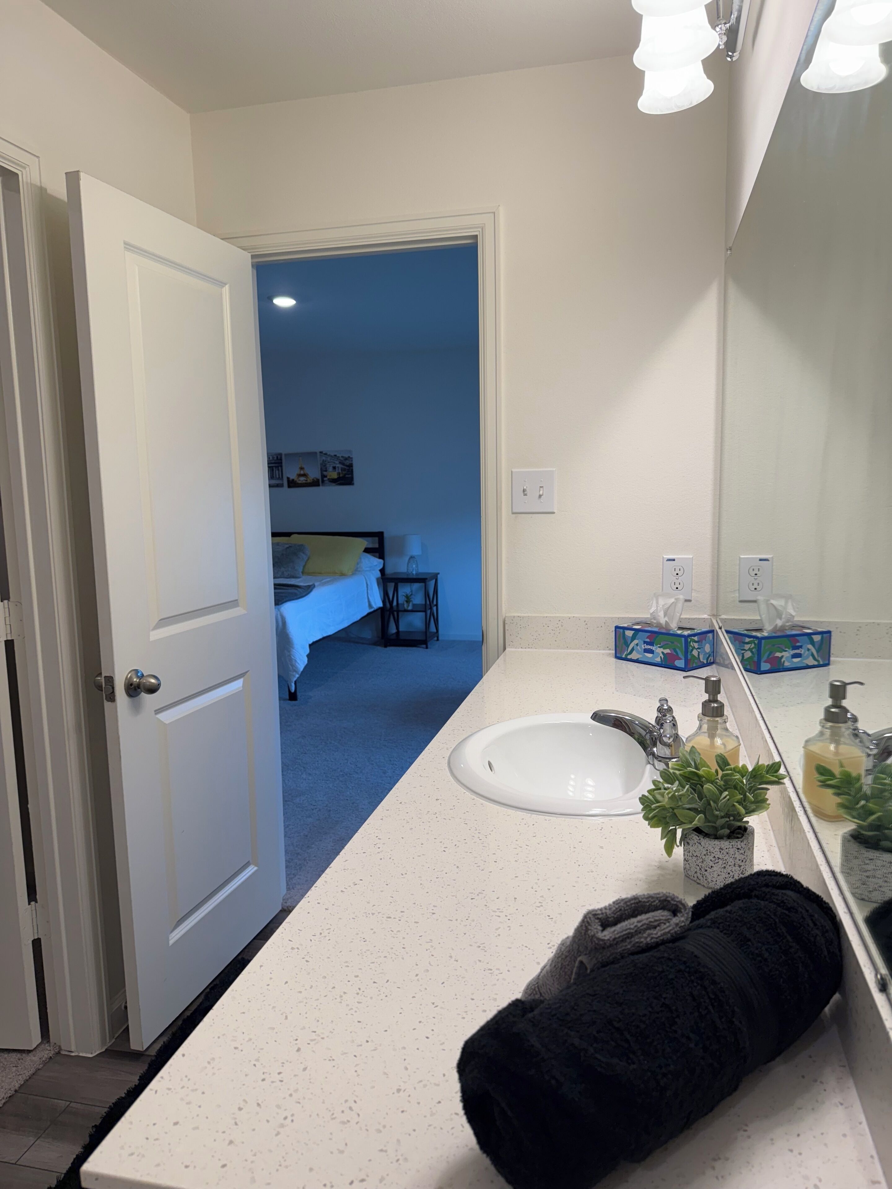Une salle de bain avec un lavabo blanc, un miroir et une serviette.