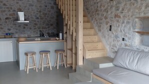 Een modern interieur met een keuken, een houten trap en een zithoek.