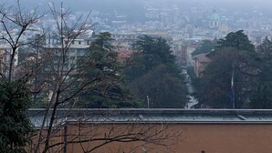 Une vue urbaine avec une colline en arrière-plan, des bâtiments et un drapeau.