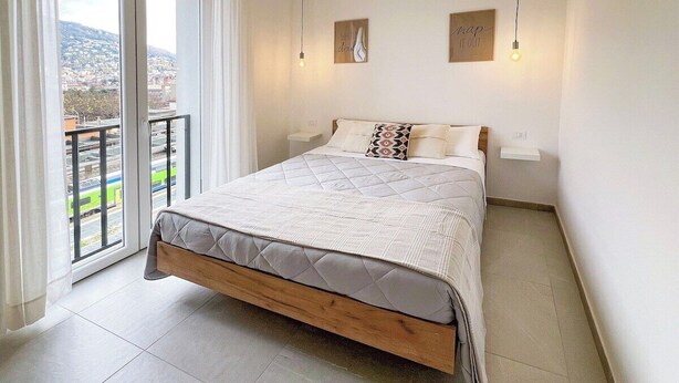 Une chambre à coucher avec un lit, une fenêtre et une vue sur le paysage urbain.
