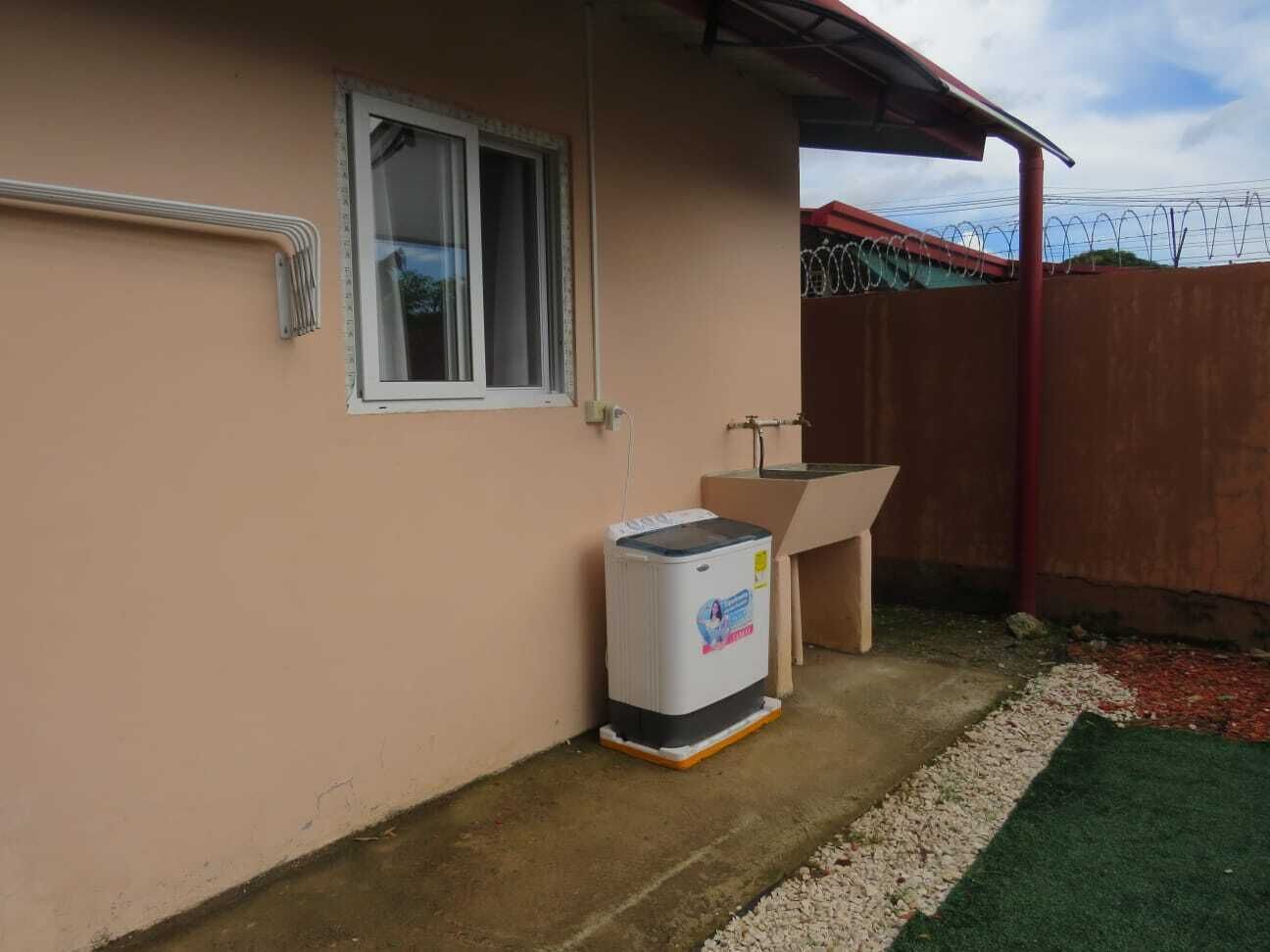 Un bâtiment doté d’une fenêtre, d’un chauffe-eau et d’un plancher en béton.