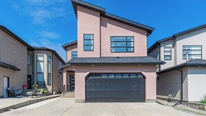 A modern two-story house with a garage, large windows, and a well-maintained exterior. - Executive lodging (Edmonton)