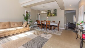 A spacious living area with a sofa, dining table, chairs, and a chandelier. - Executive lodging (Edmonton)