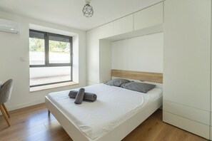 Una camera da letto moderna con un letto, una finestra e una sedia.