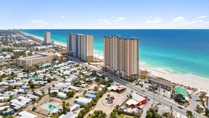 Un paisaje urbano costero con rascacielos, una playa y un puerto deportivo.