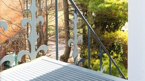 A metal staircase with ornate railings and a metal grate at the top. - Vacation apartment MeerZeit (Stein)