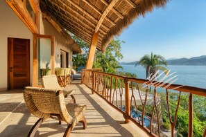 A balcony with wicker chairs, a thatched roof, and a view of the sea. - Casa Sol Bonito with Private Beach Club Access (Sayulita)