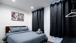 A neatly made bed with a blue bedspread, a gray pillow, and a gray stuffed toy on the bed. - Soho 2 bedroom stylish apartment (New York)