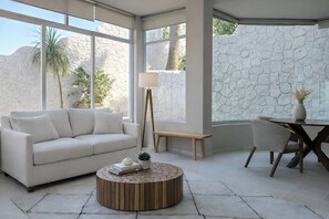 A modern living room with a white sofa, a wooden coffee table, a floor lamp, and a dining table with chairs. - Panoramic paradise with private pool and views of the Bay and Romantic Zone (Puerto Vallarta)