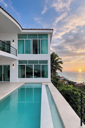A modern two-story house with a swimming pool, large windows, and a view of the ocean at sunset. - Panoramic paradise with private pool and views of the Bay and Romantic Zone (Puerto Vallarta)