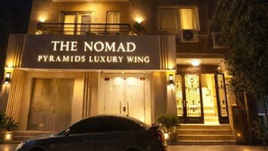 A tall building with multiple balconies and a sign reading "THE NOMAD Pyramids Luxury Wing". - The Nomad Pyramids Luxury Wing (Giza)