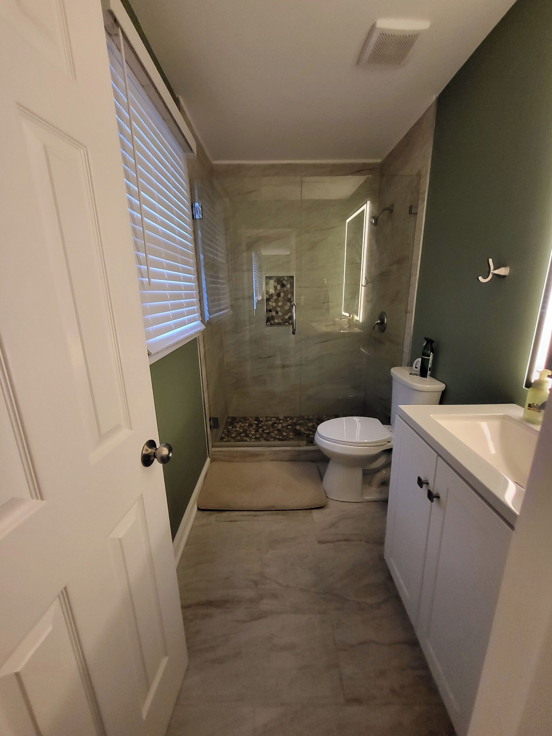 A compact bathroom with a toilet, sink, and shower area.