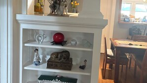 A white mantelpiece with various decorative items including figurines, a globe, and a collection of books. - Beautiful Craftsman Home in Terrific Hollywood Neighborhood (Los Angeles)