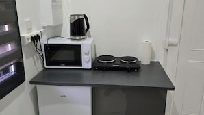 Une petite cuisine équipée d’un four à micro-ondes, d’une machine à café et d’un petit réfrigérateur.